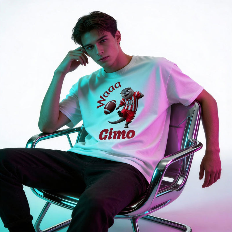 Young male wearing a white t-shirt with a graphic design and text, sitting on a modern chair.